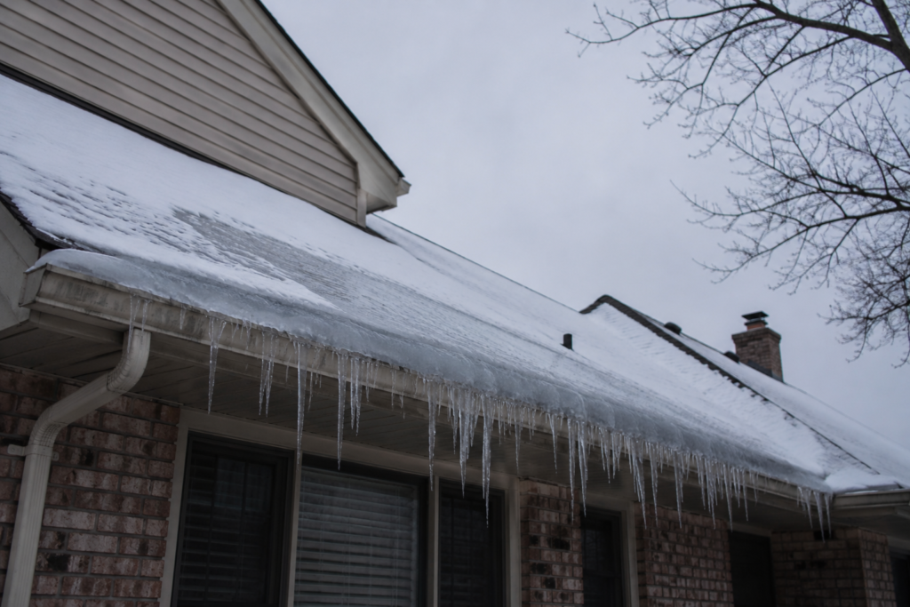 Ice dam and icicles built up along a Grand Rapids home's roofline, a common cause of winter water damage
